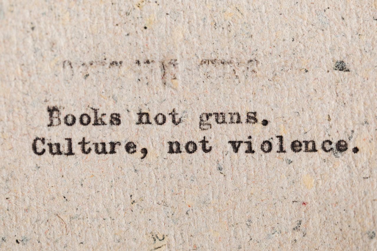 the-story A vintage typewritten quote promoting culture over violence on aged paper.